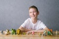 Cute boy put animal figures on the table, play with toys Royalty Free Stock Photo