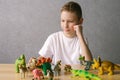 Cute boy put animal figures on the table, play with toys Royalty Free Stock Photo