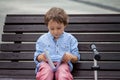 Cute boy, read a book in the park, sitting on bench, summertime Royalty Free Stock Photo