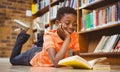 Cute boy reading book in library Royalty Free Stock Photo