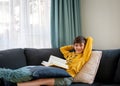 A boy reading the book on the couch in free time