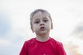 Cute Boy in a red T-shirt on the background of a stunning sunset. Journey. The face expresses natural joyful emotions. Not staged Royalty Free Stock Photo