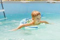 Boy relaxing on inflatable ring floating in pool have fun during summer vacation Royalty Free Stock Photo