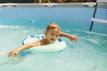 Boy relaxing on inflatable ring floating in pool have fun during summer vacation Royalty Free Stock Photo