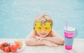 Cute boy relaxing in swim pool. Summer vacation concept. Little boy with fresh cocktail on watter pool in the summer day