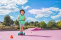 Cute boy ride baby kick scooter around cones at skate park Royalty Free Stock Photo