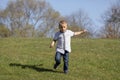 Cute boy running across grass und smiling Royalty Free Stock Photo