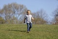 Cute boy running across grass und smiling Royalty Free Stock Photo