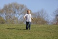 Cute boy running across grass und smiling Royalty Free Stock Photo