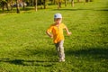 Cute boy running across grass und smiling. Royalty Free Stock Photo