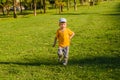 Cute boy running across grass und smiling Royalty Free Stock Photo