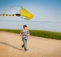 Cute boy running with fly kite beach outdoor Royalty Free Stock Photo