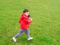 Cute boy running on green meadow Royalty Free Stock Photo