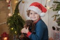 Cute boy in santa hat and dachshund puppy