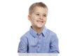 Cute boy of school age sits at the table and laughs. Isolated on a white background Royalty Free Stock Photo