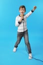 Cute boy singing in microphone on background Royalty Free Stock Photo