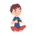 Cute Boy Sitting on Floor Playing Video Game, Teenage Kid Holding Controller Cartoon Style Vector Illustration Royalty Free Stock Photo