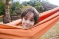 Cute boy is sitting in a hammock