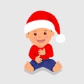 Cute boy sitting in the red Santa hat and laughs.