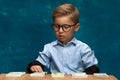 Cute boy sitting at the table and counting money Royalty Free Stock Photo