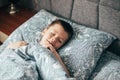 Cute boy sleeping in bed. Child 6-7 years old smiling, having a good dreams Royalty Free Stock Photo