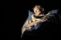 Cute boy sleeping in bed with plush toy bear Royalty Free Stock Photo