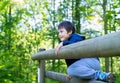 Cute boy with smiling face looking out, Candid shot happy kid playing in the park,Child having fun in a climbing on wooden fame Royalty Free Stock Photo