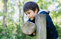 Cute boy with smiling face looking out, Candid shot happy kid playing in the park,Child having fun in a climbing on wooden fame Royalty Free Stock Photo