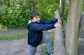 Cute boy with smiling face looking out, Candid shot happy kid playing in the park,Child having fun in a climbing on wooden fame Royalty Free Stock Photo