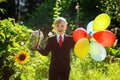 Cute boy smiling, going back to school. Boy in the suit. Child with globe and colorful balloons on first school day. Royalty Free Stock Photo