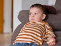 cute boy in a striped shirt eating cheesecake while watching TV Royalty Free Stock Photo