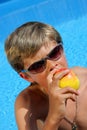 Cute Boy with sun glasses eating a delicious apple Royalty Free Stock Photo
