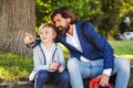 Cute boy talking with dad on a walk after school. Bearded man and his son outside