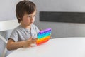 Cute boy toddler playing new pop it or simple dimple toy at home. Beautiful baby silicone toys for the development of fine motor