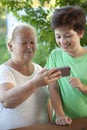 Cute boy using smartphone with grandma at home veranda Royalty Free Stock Photo