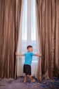 A cute boy was opening the curtains Royalty Free Stock Photo