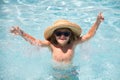 Cute boy in the water playing with water. Child boy swim in swimming pool. Smiling cute little boy in sunglasses in pool Royalty Free Stock Photo