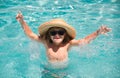 Cute boy in the water playing with water. Child boy swim in swimming pool. Smiling cute little boy in sunglasses in pool Royalty Free Stock Photo