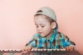 Cute boy wearing baseball cap backwards playing the digital piano Royalty Free Stock Photo