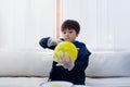 Cute boy wearing disposable protective plastic glove and holding yellow balloon,Kid preparing science project about static charged