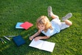 Cute boy writing on notebook outdoors. Summer camp. Kids learning and education concept. Royalty Free Stock Photo