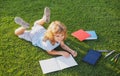 Cute boy writing on notebook outdoors. Summer camp. Kids learning and education concept. Royalty Free Stock Photo