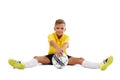 A cute boy in a yellow sports uniform holds a ball in his hands, young footballer isolated on a white background. Royalty Free Stock Photo