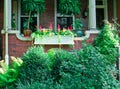 Cute brick front porch with plants and flowers.