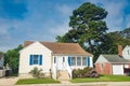 Cute brightly painted white shingled cottage with blue shutters. coastal town on sunny day