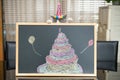 A cute british shorthair cat behind a blackboard with birthday cake celebrating her 1-year-old birthday Royalty Free Stock Photo