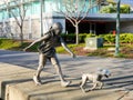 Cute bronze statue of girl playing with her dog