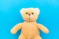 Cute brown teddy bear child toy with visible upper body and open arms isolated in a seamless pastel baby blue coulor