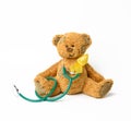 Cute brown teddy bear with a patch, a silk yellow ribbon in the shape of a loop Royalty Free Stock Photo