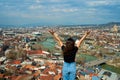 A cute brunette girl enjoys the stunning scenery of Tbilisi from the hill. The whole city at her feet